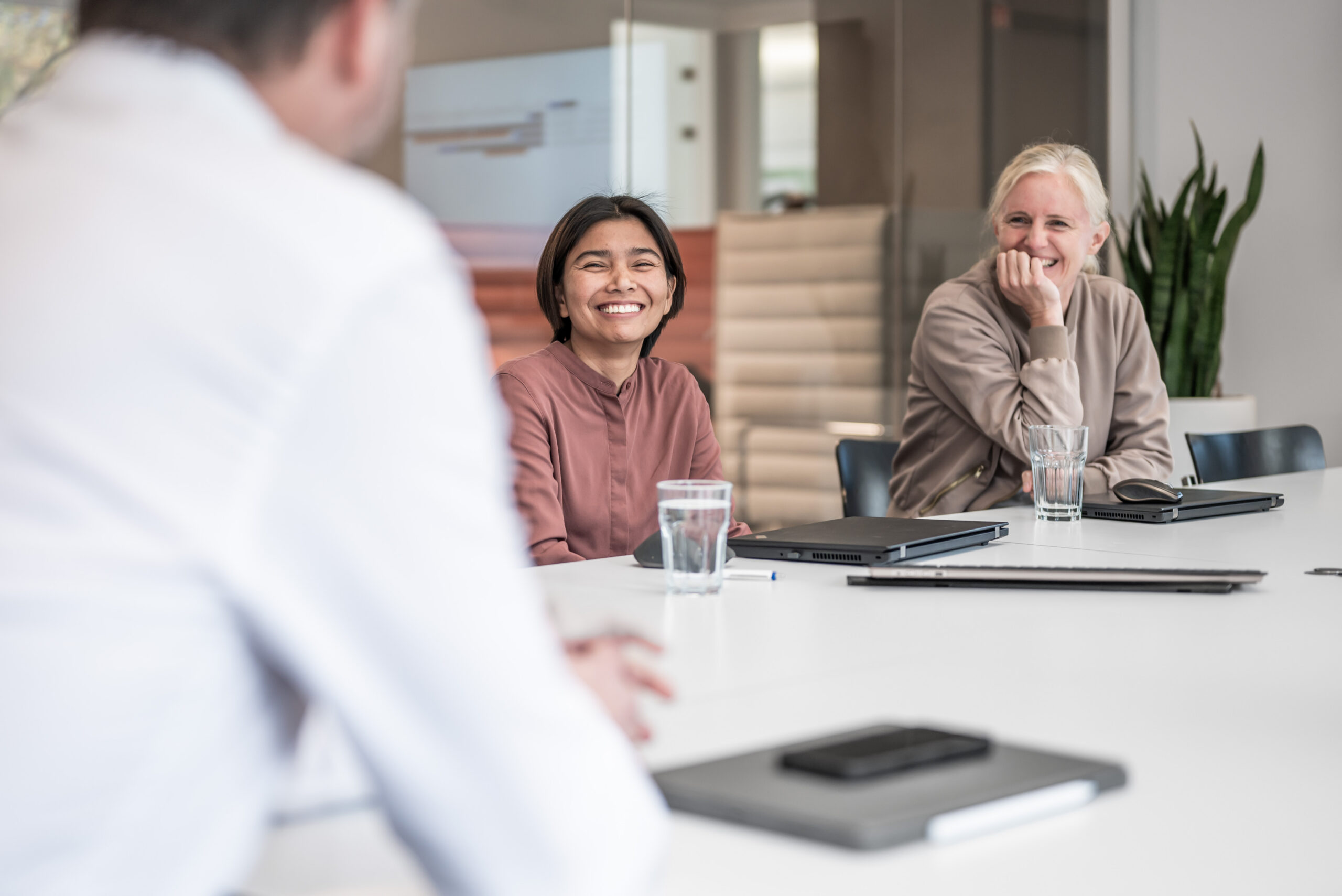 Zwei BMP-Mitarbeiterinnen lachen in einer Besprechung im Kölner Büro.