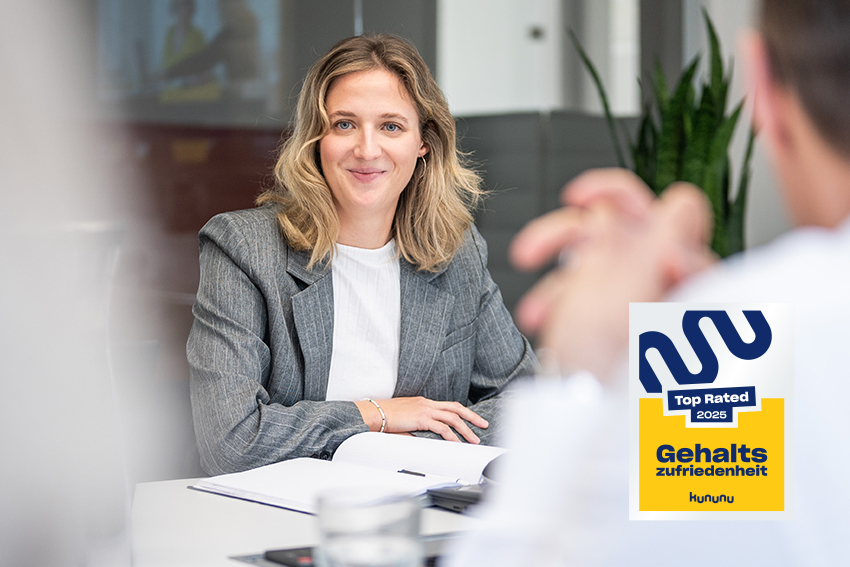 BMP Mitarbeiterin im Gespräch in einem modernen Besprechungsraum mit Kununu-Auszeichnung zur Gehaltszufriedenheit.