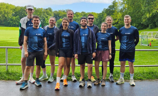 BMP Köln Laufteam beim WWF-Firmenlauf 2026 auf dem Sportplatz.