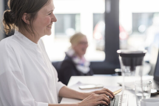 BMP-Mitarbeiterin arbeitet konzentriert im Hamburger Büro am Computer.