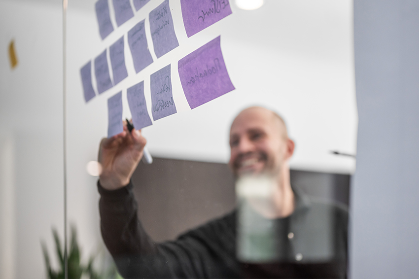 BMP Mitarbeiter bei der Arbeit an einer Workshop-Wand mit farbigen Notizzetteln.